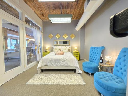 Pike Place Sky Palace Residences في سياتل: غرفة نوم بسرير وكرسيين ازرق