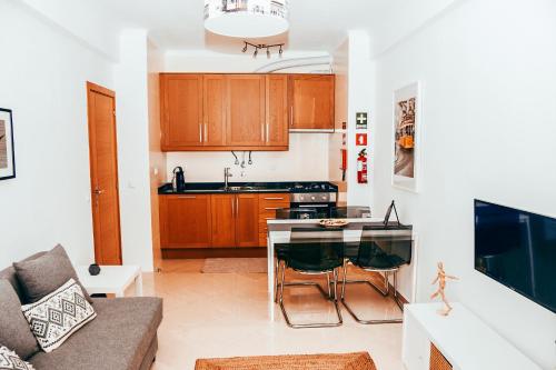 a kitchen and living room with a table and a couch at Giestal Terrace By Gt House in Lisbon
