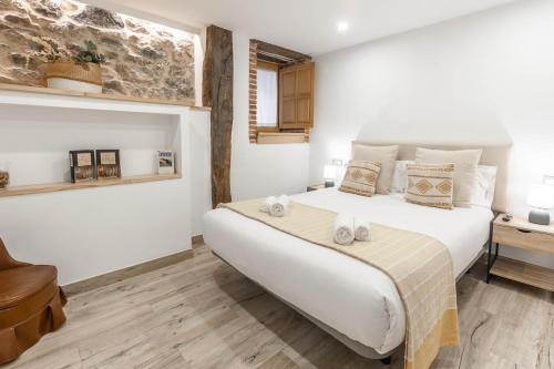 a bedroom with a large white bed and a desk at El patio, apartamento en casco histórico con vistas a la iglesia in Castro-Urdiales