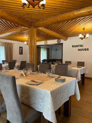 Pensiunea Rustic House Rucăr - Argeș في روكار: غرفة طعام مع طاولات وكراسي ومنزل ريفي