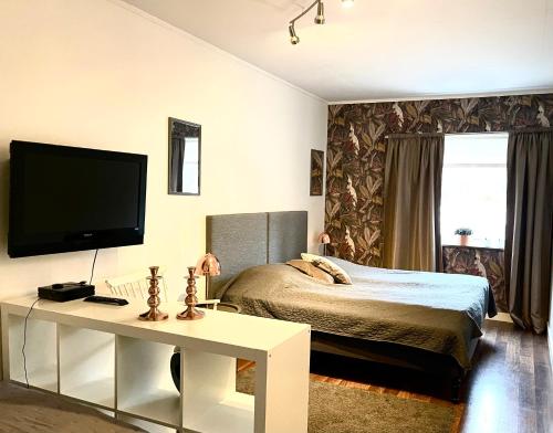 une chambre avec un lit et une télévision au mur dans l'établissement Ängshöjd, à Sandhem