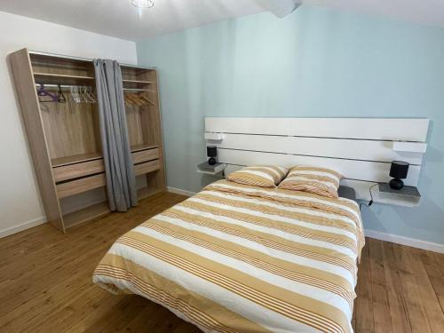 a bedroom with a bed and a closet at L'Ecrin de Verdun in Verdun-sur-Meuse