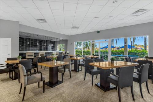 a dining room with tables and chairs and windows at 3 Bedrooms 25 Bathrooms Encantada 3091 Yl in Orlando