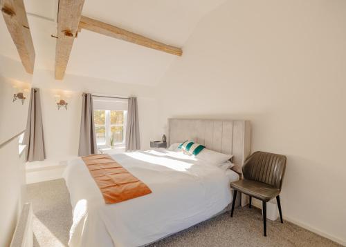 Bamber BridgeにあるYe Olde Original Withy Treesのベッドと椅子のある白い寝室