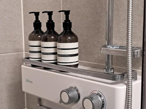 drei Flaschen Wein stehen auf einem Regal in einem Badezimmer in der Unterkunft Cozy Stay #Songdo Dalbit Festival Park in Incheon