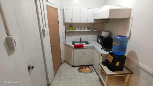 - une petite cuisine avec un évier et une plaque de cuisson dans l'établissement Kochimoto Guestroom, à Baguio