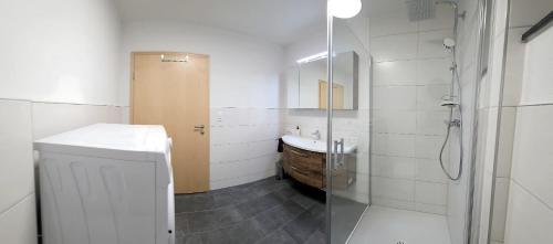 兰格尔斯道夫Konis Ferienwohnung的浴室里有马桶、洗手池和淋浴。