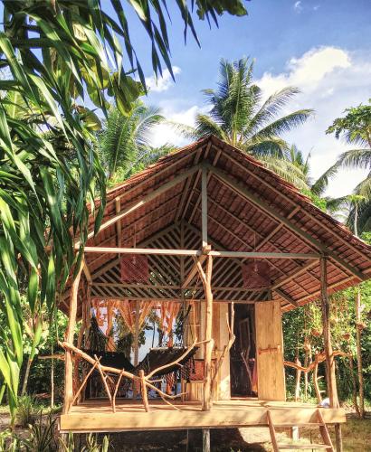 a small bamboo house with a thatched roof at Poki Poki - Togian Islands in Bomba