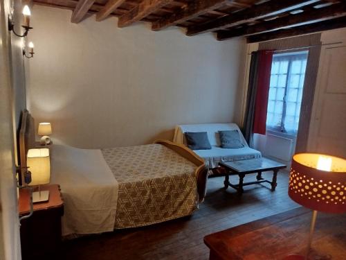 une chambre d'hôtel avec un lit et un canapé dans l'établissement Gîte Chez Marcel, à Spoy
