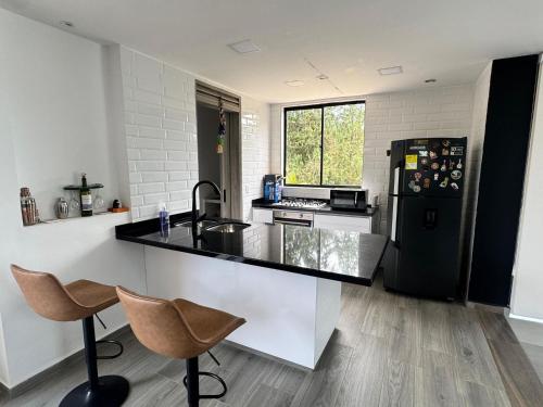 una cucina con un frigorifero nero e un bancone di Black Friday en Casa de Campo Campestre ZEN a La Granja