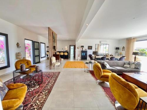 ein Wohnzimmer mit Couch und Stühlen in der Unterkunft Villa Blanche in Ngaparou