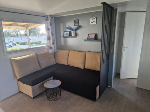 a living room with a couch and a window at TRIGANO Savina 2022 in Litteau