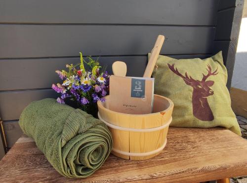 ein Holztisch mit einem Korb und Blumen darauf in der Unterkunft Limerhof in Waischenfeld