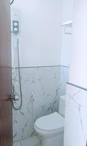 a white bathroom with a toilet and a shower at 101 Casa de Rany in Dumaguete