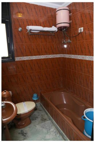 a bathroom with a tub and a toilet and a sink at Hotel The R Blues - Near IGI Airport New Delhi in New Delhi