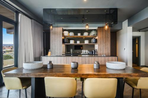 a dining room with a wooden table and chairs at The Capital Boardwalk in Gqeberha