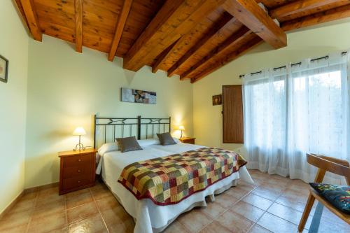 a bedroom with a bed and a large window at Posada La Canal in Ubiarco