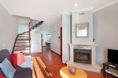 a living room with a fireplace and a staircase at Duplex Apartamento Peixe Balão in Santa Luzia