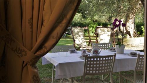 ein Tisch mit einer weißen Tischdecke und Stühle mit Blumen in der Unterkunft Geräumige Zweizimmerwohnung in Pesaro