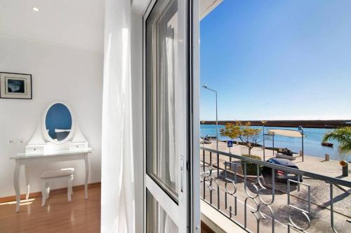 a room with a balcony with a view of the beach at Duplex Apartamento Peixe Balão in Santa Luzia