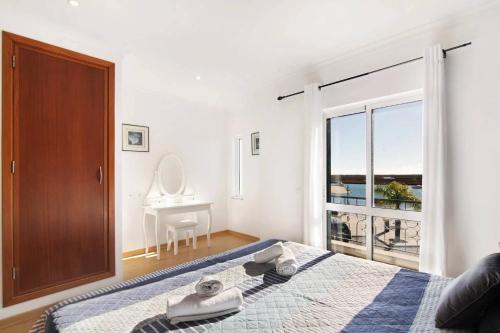 a bedroom with a bed and a window with a desk at Duplex Apartamento Peixe Balão in Santa Luzia