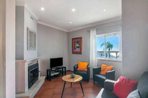 a living room with a couch and a tv at Duplex Apartamento Peixe Balão in Santa Luzia