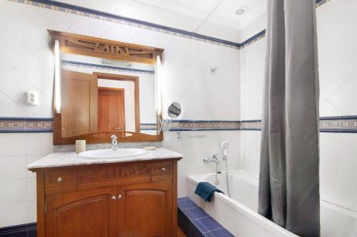 a bathroom with a sink and a tub and a mirror at Duplex Apartamento Peixe Balão in Santa Luzia