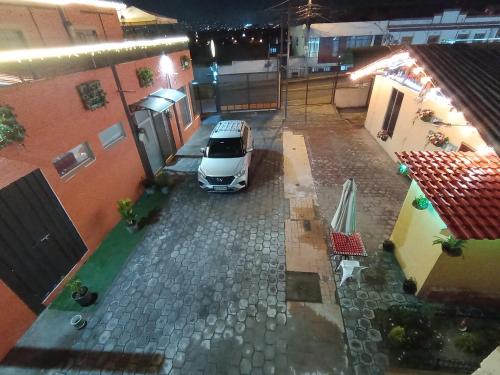 un coche aparcado en un aparcamiento entre dos edificios en CHAKIÑAN Hospedaje y Eventos OFICIAL, en Tumbaco