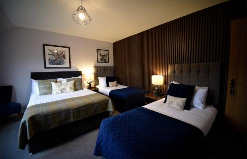 a hotel room with two beds and a chair at Stonefield House in Portree