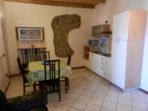 Il comprend une cuisine équipée d'une table et d'un réfrigérateur. dans l'établissement Appartasmento Ficus, à bedizzol