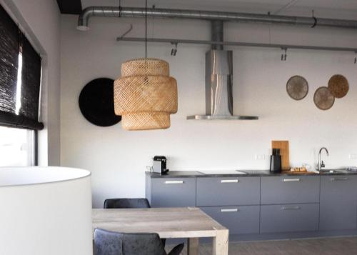 a kitchen with a table and some baskets hanging from the wall at Dock Hotel Stellendam in Stellendam