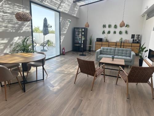 ein Wohnzimmer mit einer Couch sowie Tischen und Stühlen in der Unterkunft Hotel Síbel Baza in Baza