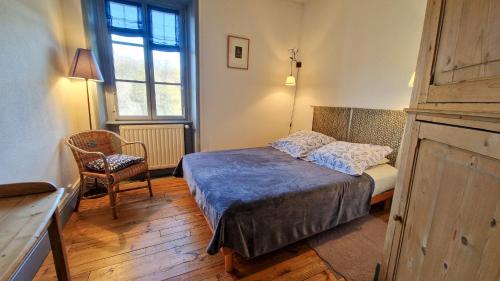 a small bedroom with a bed and a chair at Chambres d'hôtes La Marche des Bois in Crocq