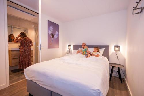 Eine Frau und ein Kind auf einem Bett in der Unterkunft Vakantiepark BreeBronne in Maasbree