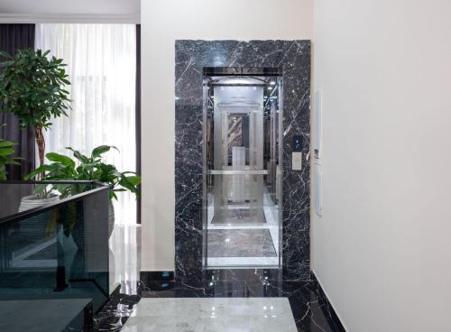 ein Bad mit schwarzen Marmorwänden und einem Spiegel in der Unterkunft Novo Sky Hotel in Baku