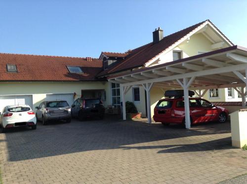 a garage with cars parked in front of a house at Ferienwohnung Haus Anja In Bad Füssing in Bad Füssing