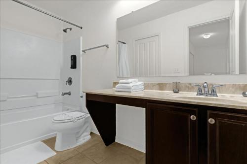 a bathroom with a sink and a toilet and a bathtub at 5 Bedrooms 5 Bathrooms Crystal Cove 1042Td in Kissimmee