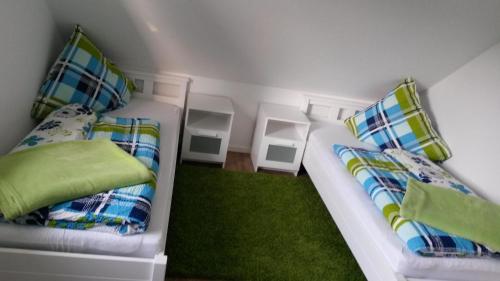 a room with two beds and a green rug at Lütt Gammelby in Gammelby