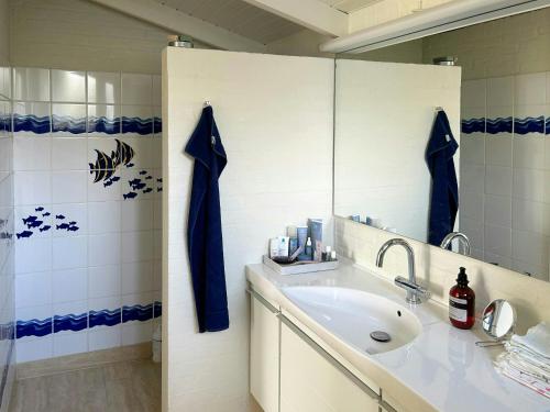 une salle de bain avec un lavabo et un miroir dans l'établissement Sommerhus Med Sjæl Få Skridt Fra Vandkanten, à Martofte