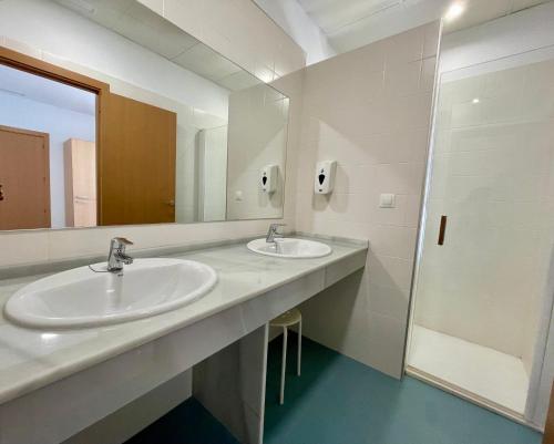 a bathroom with two sinks and a mirror at Geysotur Torrox Playa Apartamentos in Torrox