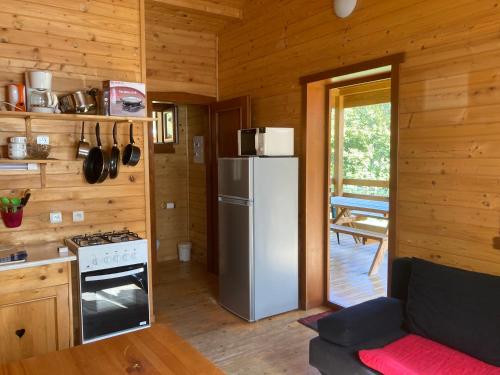 a kitchen with a refrigerator and a stove at Camping, Hôtel De Plein Air Les Cariamas in Chateauroux-les-Alpes