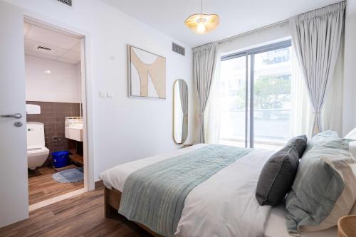 a bedroom with a bed and a bathroom with a window at Tula Thaara Duplex with Private Beach and Pool in Al Marjan Island in Ras al Khaimah