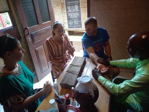 eine Gruppe von Menschen, die um einen Tisch herum sitzen in der Unterkunft Sirilaka Wedagedara in Alutwala