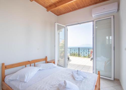 een slaapkamer met een bed en een balkon bij Seaside Holiday House by elite in Psarou