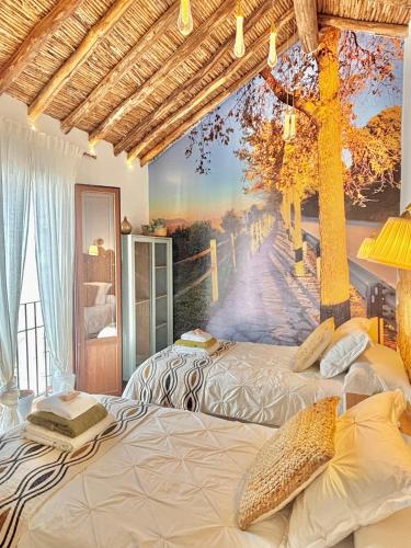 two beds in a room with a painting on the wall at Recuerdos del Sur in El Gastor