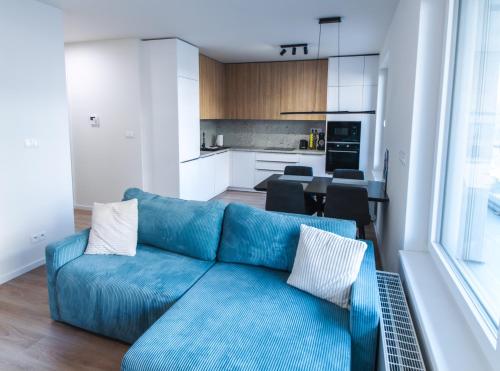 een woonkamer met een blauwe bank en een keuken bij Doctor's Cosy Apartment in Lamač