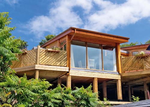 a large wooden house with glass windows on it at Landal Leycroft Valley in Perranzabuloe