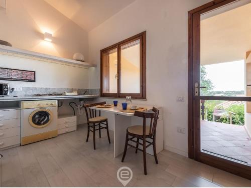 a kitchen with a table and chairs and a sink at Porto Luna 25 - Hala in Simius