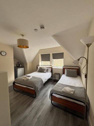 a bedroom with two beds and a lamp at TLK Apartments & Hotel - Beckenham Junction in London