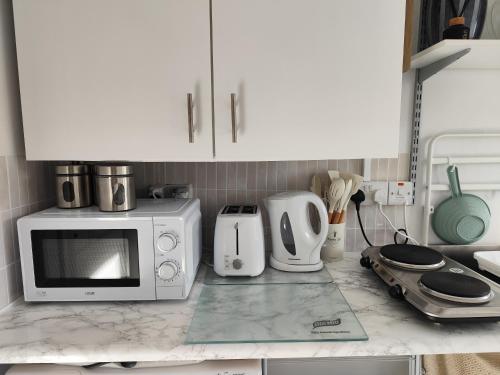a kitchen counter with a microwave and other appliances at Amy's Suite in Killarney